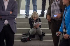 Eine Besucherin wartet in ihre Unterlagen vertieft auf das Resultat des zweiten Wahlgangs. (Bild: Benjamin Manser)