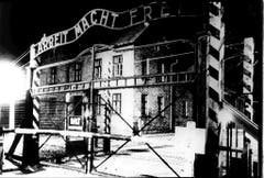 Die Toraufschrift "Arbeit macht frei" prangt über dem Eingang zum Stammlager Auschwitz I, hier in einer Aufnahme von 1945. Geschmiedet wurde der Schriftzug vom polnischen Häftling Jan Liwacz, der aus Protest gegen seine Peiniger das "B" verkehrt herum angebracht haben soll. (Bild: Keystone)