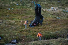 Ein Armee-Fotograf schiesst Fotos von einem Helikopterteil. (Bild: Keystone)