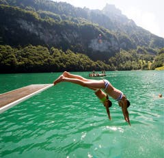 Zwei Schwimmerinnen erfrischen sich mit einem Sprung ins kühle Nass. (Bild: Keystone)