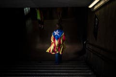 Eine Frau mit einer "estelada", der Unabhängigkeitsflagge der Katalanen. Im September feierten Hunderte von ihnen die Unabhängigkeitserklärung vor dem Präsidentenpalast in der Altstadt von Barcelona. Einige Tage später war von der Freude nicht viel übrig. Wenige Stunden nach ihrer Geburt setzte die spanische Regierung die katalanische Führung ab. (Bild: SANTI PALACIOS (AP))