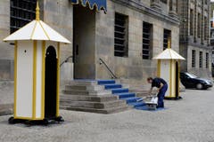 Der Teppich vor dem Königspalast wird gesaugt. (Bild: Keystone)