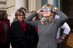 Die Basler SP-Nationalraetin Susanne Leutenegger Oberholzer verfolgt mit einer Schutzbrille das Naturspektakel der partiellen Sonnenfinsternis auf dem Balkon des Bundeshauses. (Bild: Keystone)