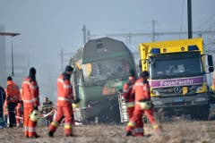 Polizei und Feuerwehr an der Unfallstelle des Zugungluecks bei Rafz, Kanton Zuerich, am Freitag, dem 20. Februar 2015. Bei der Kollision zwischen zwei Personenzuegen am fruehen Morgen wurden fuenf Personen verletzt, eine davon schwer. (KEYSTONE/Ennio Leanza)..Police and firemen a the accident site in Rafz, canton Zurich, Switzerland, on Friday, February 20, 2015. The collision of two passenger trains in the early morning caused five injured, one of them severe. (KEYSTONE/Ennio Leanza) (Bild: Keystone)