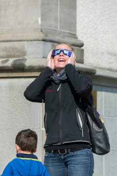Man sieht wirklich etwas! Eine Frau ist entzückt von der Sonnenfinsternis. (Bild: Urs Bucher)