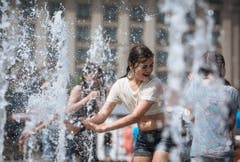 Ein Mädchen vergnügt sich bei einem Wasserspiel in der ukrainischen Hauptstadt Kiew. (Bild: ROMAN PILIPEY (EPA))