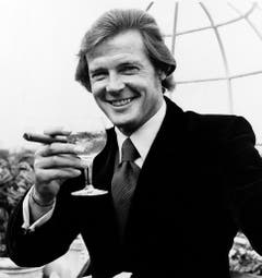 Geschüttelt und nicht gerührt! Roger Moore mit Zigarre und Martini. Aufgenommen wurde dasd Bild 1972 während der Dreharbeiten zu "Live and Let Die". (Bild: Keystone)