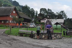 Der Melser Gemeindepräsident Guido Fischer spricht beim Dorfbrunnen mit einer betroffenen Anwohnerin. (Bild: Sarganserländer/Michael Kohler)