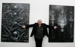 H.R. Giger posiert vor zwei seiner Bilder aus dem Jahre 1976 und 1974. (Bild: Keystone)