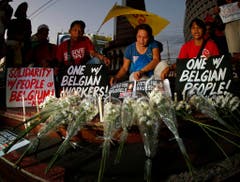 Filipinos lay flowers for victims of terror attacks in Brussels at a park in Manila (Bild: Keystone)