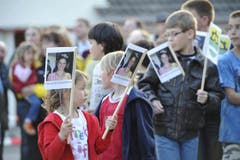 Schulkinder mit Fähnchen, auf denen die Miss abgebildet ist. (Bild: Hanspeter Schiess)