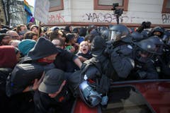Polizisten versuchen die Protestanten in den Griff zu bekommen. (Bild: Keystone)