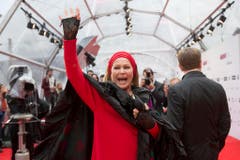 Die Schweizer Filmlegende Ursula Andress grüsst die Fans auf dem roten Teppich. (Bild: Keystone)