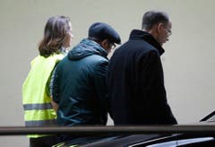 Ein Care-Team-Mitglied führt zwei Männer weg, die auf Passagiere des Unglücksflugs gewartet haben. (Bild: Keystone)