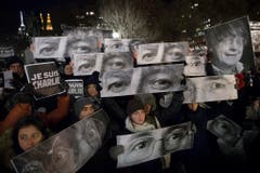 In New York haben die Trauernden Schilder mit den Augen der ermordeten Charlie Hebdo Mitarbeitern hochgehalten. (Bild: Keystone)