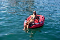 Eine junge Frau geniesst den Sommer auf einem Schlauchboot auf dem Zürichsee. (Bild: WALTER BIERI (KEYSTONE))