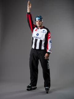 Angezeigte Strafe (IIHF-Regel 114): Hat das Team, das die Strafe verursacht, keine Puckkontrolle, streckt der Schiedsrichter seinen Arm (den ohne Pfeife) gerade in die Höhe, um damit anzuzeigen, dass eine Strafe ausgesprochen wird, dabei unterbricht er das Spiel nicht bis: 1_Das fehlbare Team die Puckkontrolle erlangt; 2_Der Puck blockiert ist; 3_Der Puck aus dem Spielfeld gelangt; 4_Das Team mit Puckkontrolle ebenfalls ein Foul begeht; 5_Andere Gründe, die ebenfalls im Regelwerk beschrieben werden. (Bild: Keystone)