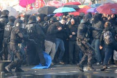Die Polizei versucht die Demonstranten in Schach zu halten. (Bild: Keystone)