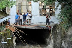 Schaulustige werfen einen Blick in eine zerstörte Industrieliegenschaft an der «Unteren Fabrik». (Bild: Michel Canonica)