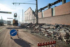 Angestellte der Stadt reparieren eine defekte Stromleitung neben einer Zinkfabrik. 600 Quadratmeter des Fabrikdachs wurden durch die Druckwelle weggefegt. (Bild: Keystone)