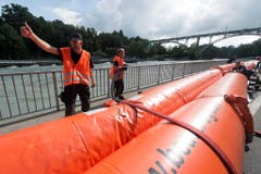 In Bern montieren Feuerwehrleute mobile Hochwasserschutzdämme am Aare-Ufer. (Bild: Keystone)