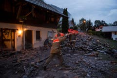 Zivilschützer auf dem Weg zu Aufräumarbeiten. (Bild: Keystone)
