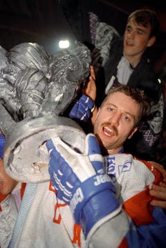 Klotens Spieler Peter Schlagenhauf stemmt 1993 den Meisterpokal in die Höhe. Die Zürcher Unterländer waren der erste "bärtige" Schweizer Meister. (Bild: Keystone)
