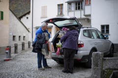 Zwei Dorfbewohner entladen ihr Hab und Gut. (Bild: KEYSTONE/Gian Ehrenzeller)