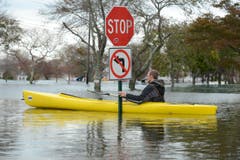 Hochwasser nach Supersturm Sandy, soweit das Auge reicht - und trotzdem scheint sich dieser Mann an die Signalisation zu halten. (Bild: Keystone)