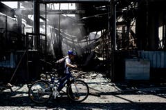Ein Kind läuft mit seinem Fahrrad durch das zerstörte Saurer-Areal. (Bild: Keystone/Ennio Leanza)