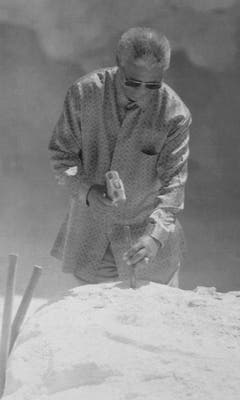 Nelson Mandela demonstriert, wie er während seiner Gefangenschaft auf Robben Island Kalkstein abbauen musste (1995). (Bild: Keystone)