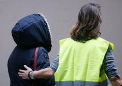 Eine Angehörige wird am Flughafen Düsseldorf weggebracht. (Bild: Keystone)