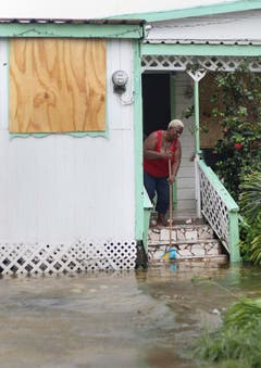 Ein Frau wischt Wasser aus dem Haus nachdem der Tropensturm Irma St.John's, Antigua and Barbuda passiert hat. (Bild: Keystone)