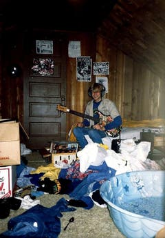 Mit der Gitarre im Dachboden: Ein undatiertes Foto zeigt den jungen Kurt Cobain in seinem Elternhaus in Aberdeen. Mit 14 erhielt er seine erste Gitarre von seinem Onkel Chuck. (Bild: Keystone)