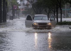 Ein Pickup fährt durch die geflutete Brickell Avenue in Miami, Florida. (Bild: Keystone)
