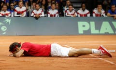 Erschöpft liegt Roger Federer nach dem Spiel am Boden. (Bild: Keystone)
