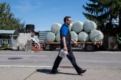 Ein Polizist patroulliert vor dem Hof von Ulrich Kesselring. (Bild: Keystone)