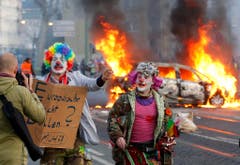 Demonstranten in Clown-Kostüms protestieren gegen den Kapitalismus. (Bild: Keystone)