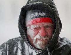 Der Ladenbesitzer Allan Umscheid wagt sich in Lawrence, Kansas, zum Schneeräumen raus. Und spürt sofort den eisigen Wind. (Bild: Keystone)