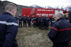 Feuerwehrleute und Sanitäter besprechen ihren Einsatz. (Bild: Keystone)