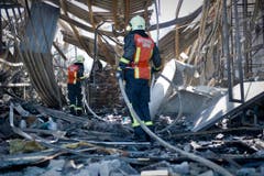 Feuerwehrmänner auf der Suche nach Glutnestern. (Bild: Urs Bucher)