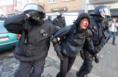 Polizisten führen eine verletzte Demonstrantin ab. (Bild: Keystone)