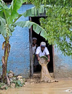 Auch an Haiti ist «Sandy» vorbeigezogen. In La Plaine befreien die Bewohner ihre Häuser vom angespülten Schlamm. (Bild: Keystone)
