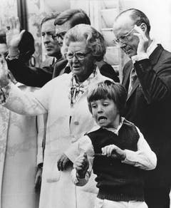 Am 2. Mai 1978 zielt der zehnjährige Prinz Johan Friso mit einem elastischen Band auf die Kameramänner während seine Grossmutter Königin Juliana und Grossvater Prinz Bernhard am 69. Geburtstag der Königin der Menge zuwinken. (Bild: Keystone)