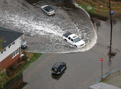 Ein Auto fährt nach dem Sturm durch die Wassermassen in Little Ferry, New Jersey. (Bild: Keystone)