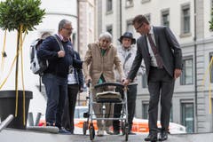 Ruth Roduner wird von ihrem Sohn Dieter (links) und Hanspeter Krüsi, Chef Kommunikation der Kantonspolizei St.Gallen, zur Feier geleitet. (Bild: Keystone)