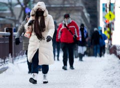 Dick vermummt eilen Menschen durch eine Strasse von Chicago. (Bild: Keystone)