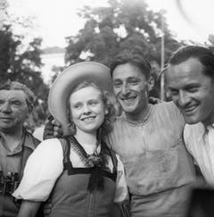 Ferdy Küber, der Sieger der zweiten Hälfte der 3. Etappe der 12. Tour de Suisse, am 14. Juni 1948 von La-Chaux-de-Fonds nach Thun, posiert am Ziel mit einem Mädchen in Tracht. (Bild: Keystone)