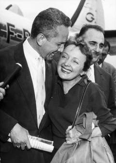 Zurück in Paris nach einer 18-monatigen Konzerttournée durch die USA: Edith Piaf wird am 8. August 1957 am Flughafen Paris-Orly von ihrem langjährigen guten Freund Marcel Blistène (links) und Bruno Coquatrix, Direktor des legendären Konzertsaals "Olympia" in Paris, begrüsst. (Bild: Keystone)