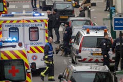 Polizisten und Rettungskräfte vor dem Redaktionsgebäude des Satiremagazins in Paris. (Bild: Keystone)
